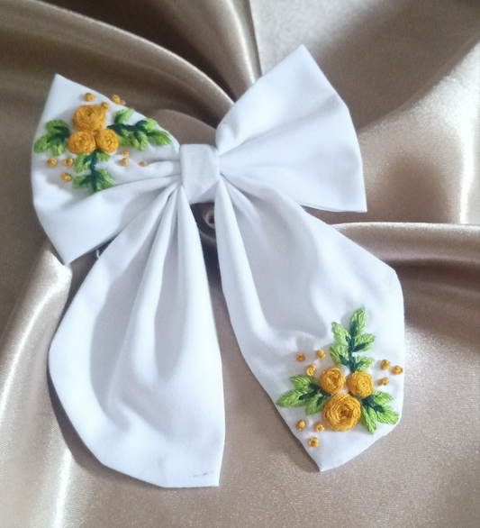 Elegant white bow with hand-embroidered yellow floral design